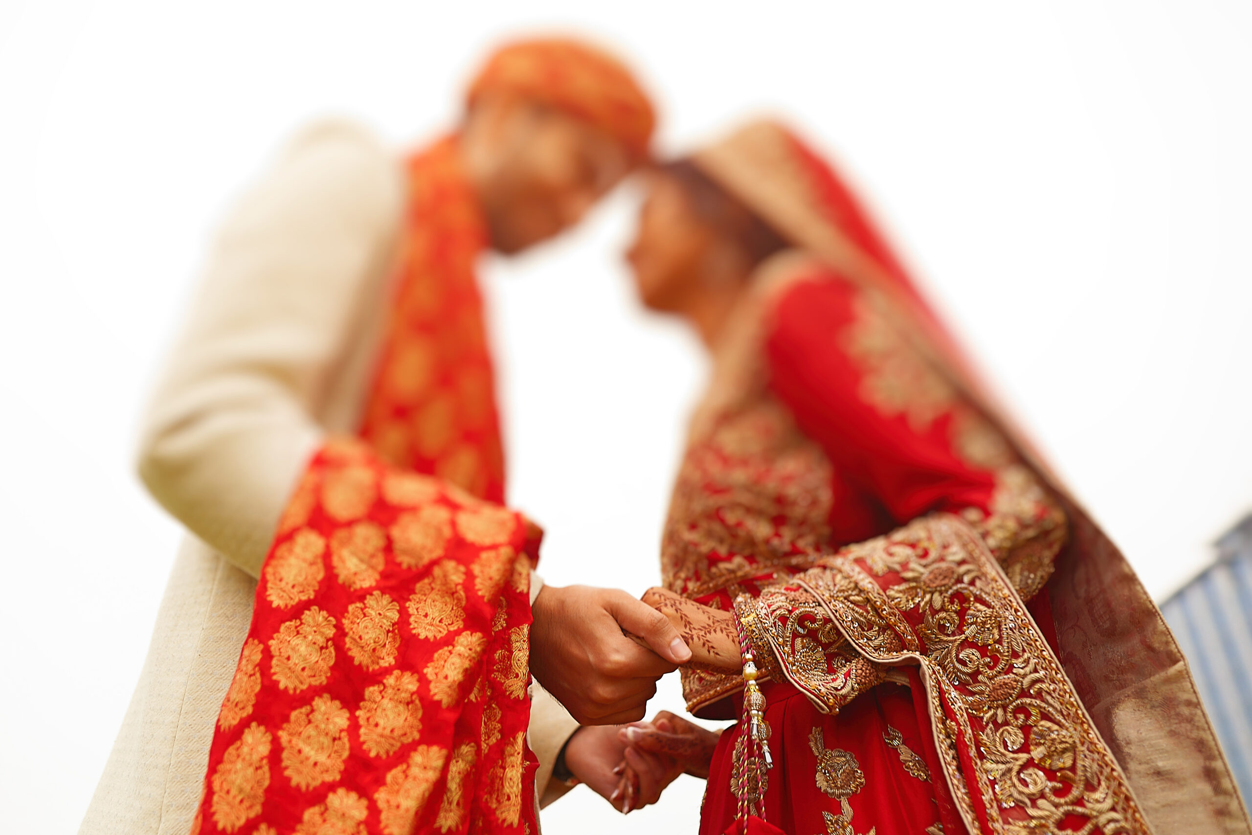 hindu bride walks behind husband holding garb