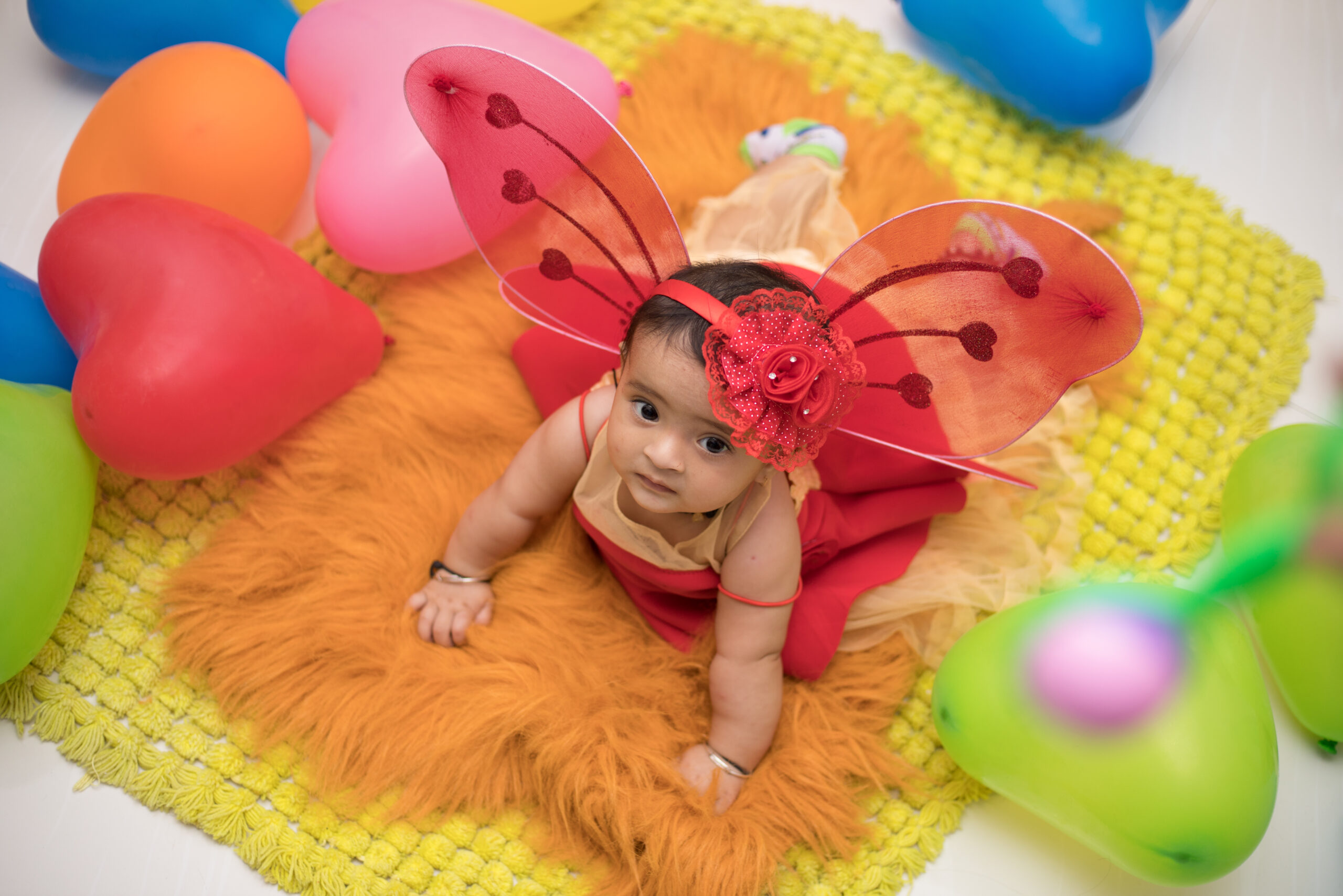 A top view shot of an Indian baby girl with a colorful butterfly dress in Mumbai, India